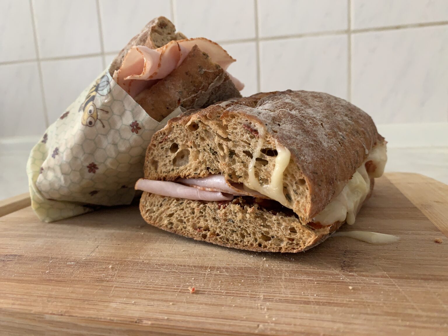 photo showing sandwich cut in half and wrapped in beeskin beeswax wraps size M in kids design