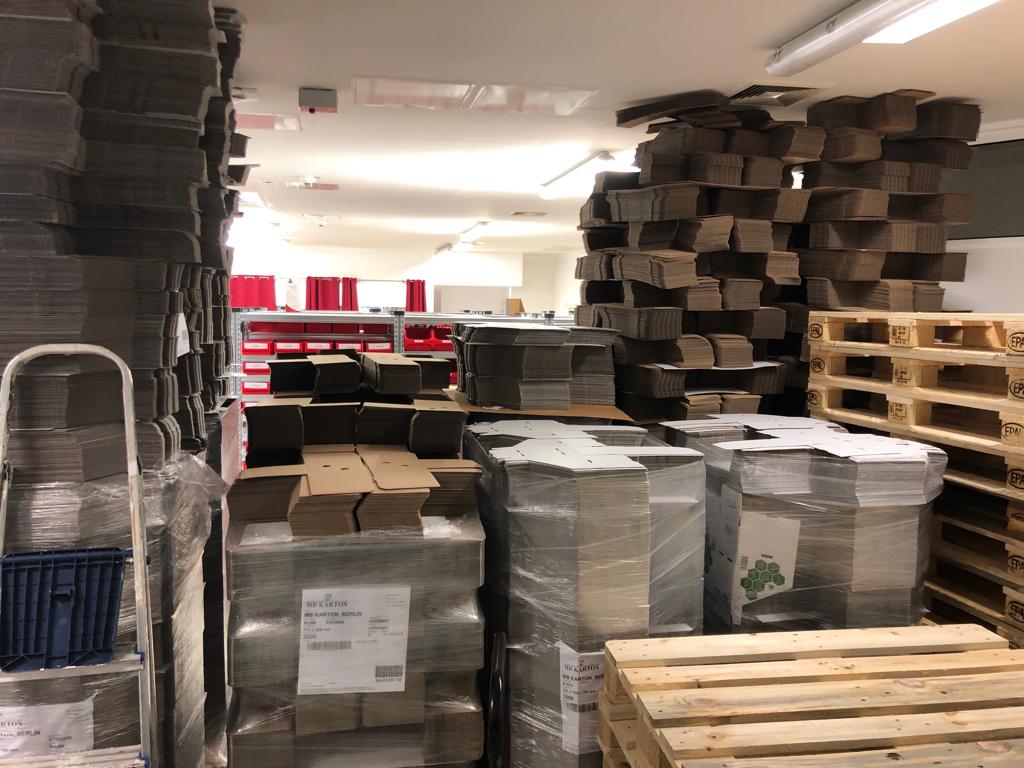 warehouse room containing cartons, wooden pallets, packaging