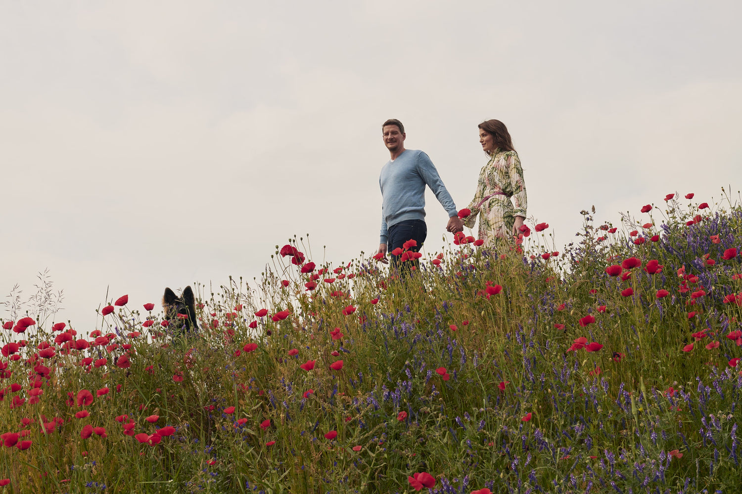 Christina and Christian Sauer, CEO founder of beeskin walking down a meadow with red flowers