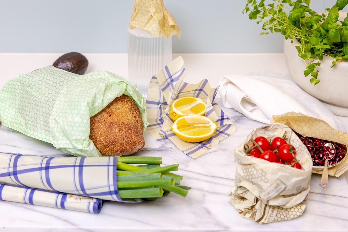 food- bread, lemon, tomatoes, leak wrapped in beeswax wraps and bags