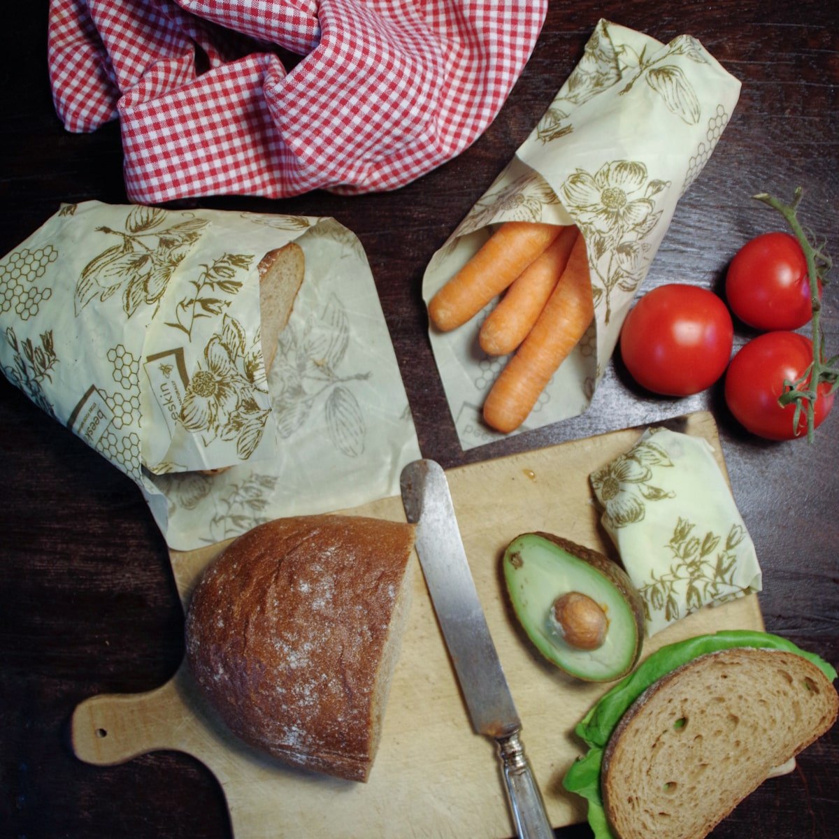 beeskin beeswax wrap multi flower wrapping a bread, avocado and carrots