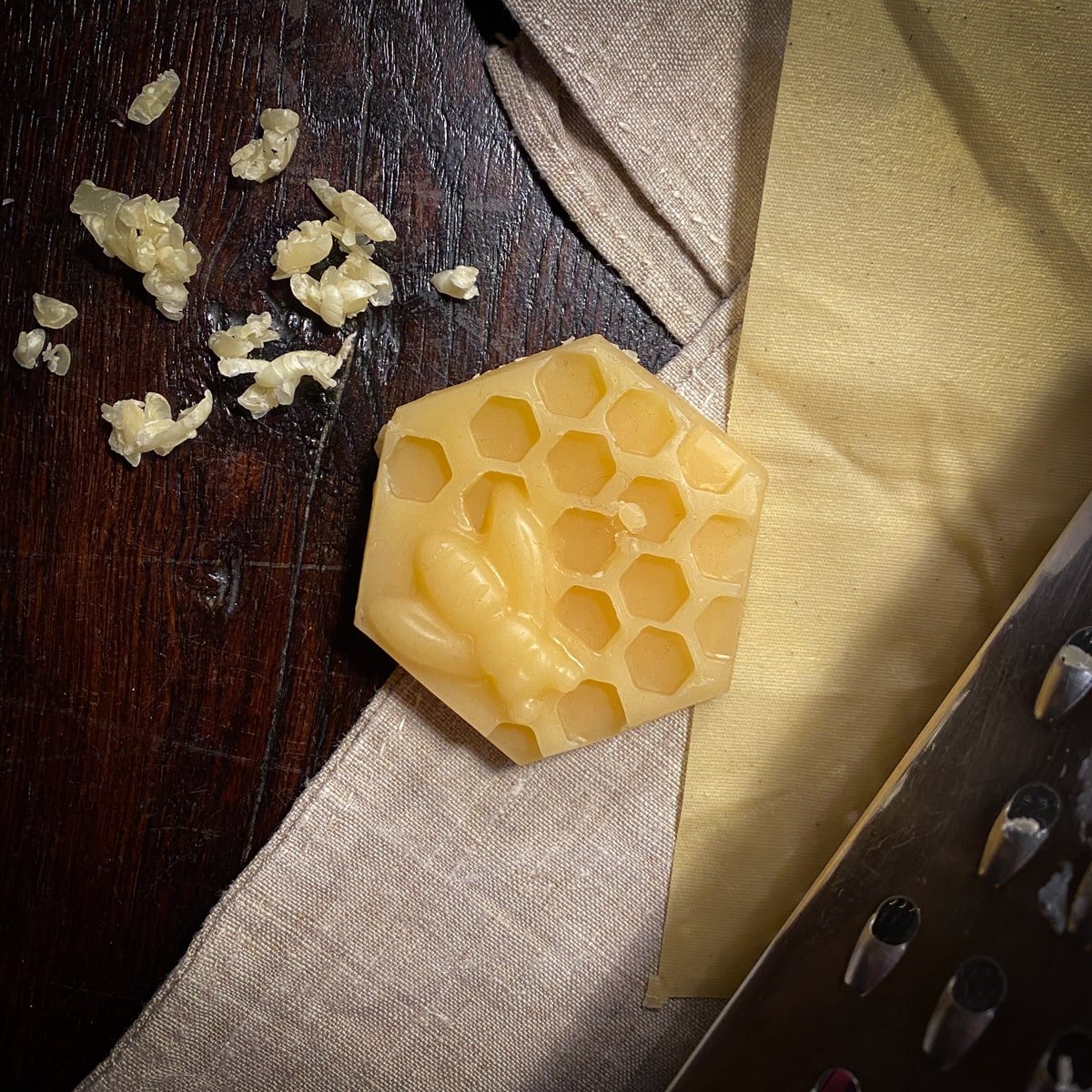 beeswax repair set and crumbs of it on a wooden table