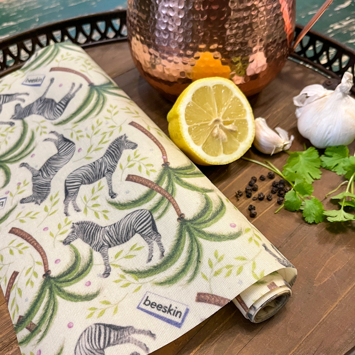 beeswax roll zebra on a tablet next to lemon, garlic and herbs