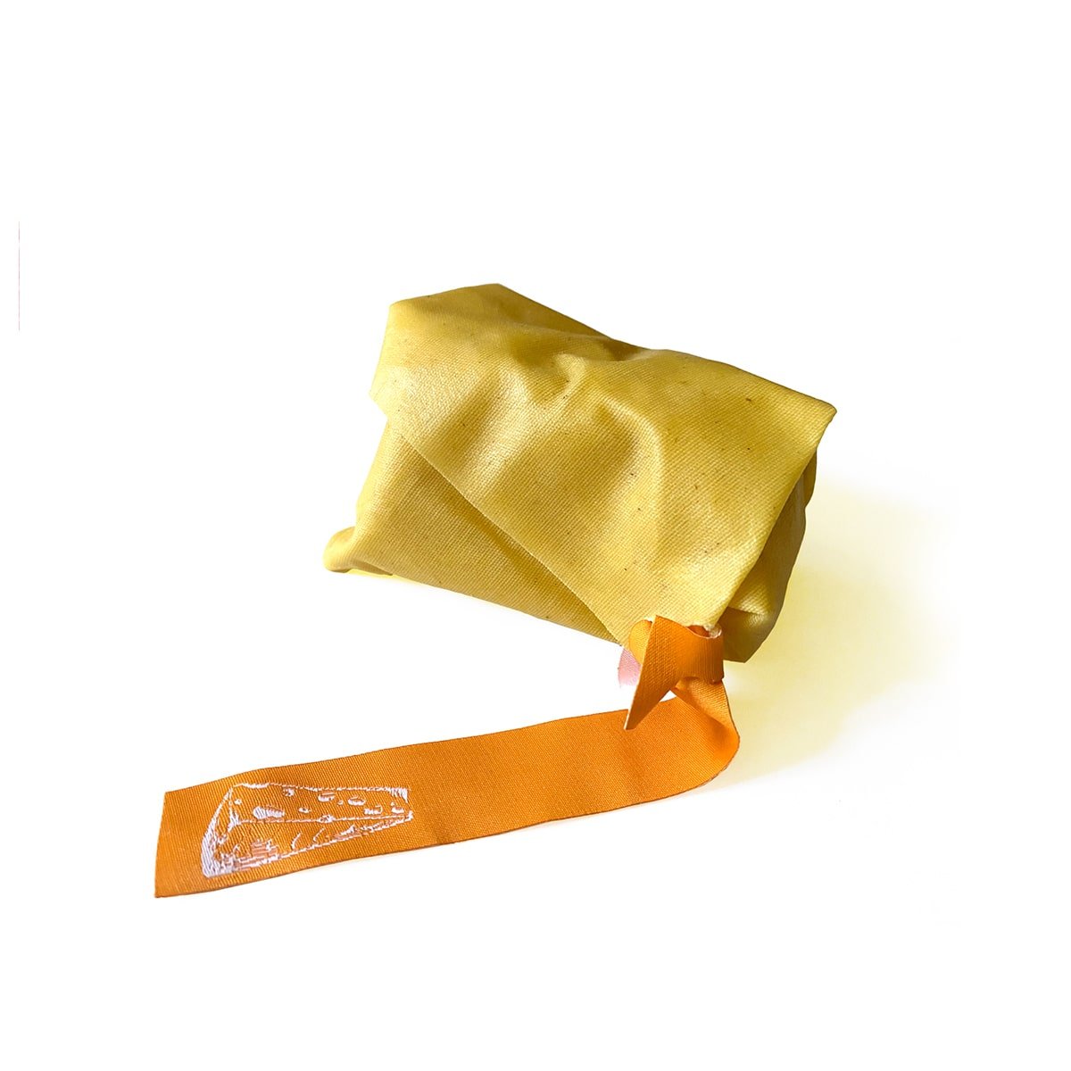 piece of cheese wrapped in beeskin unprinted. orange "cheese" label attached to one corner.