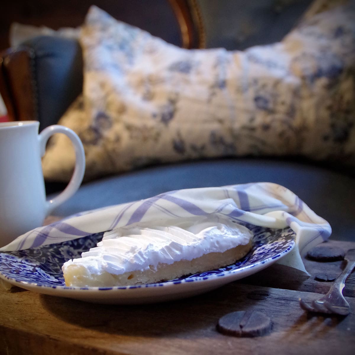 lemon cheesecake on a plate covered by beeskin beeswax wrap m kitchen standing on a wooden table