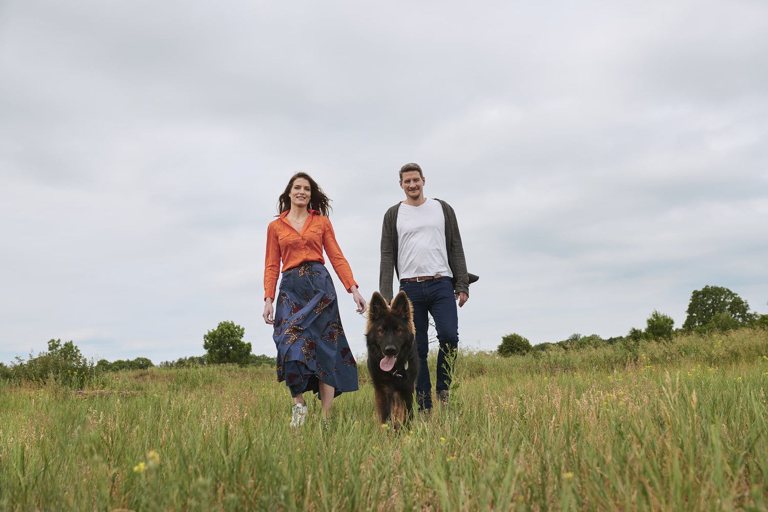 Christina and Christian Sauer, CEO of beeskin on a flower meadow  with a dog