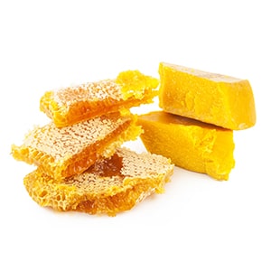 blocks of beeswax on the right side of the image. on the left there are honey combs stacked on top of each other. white background. 