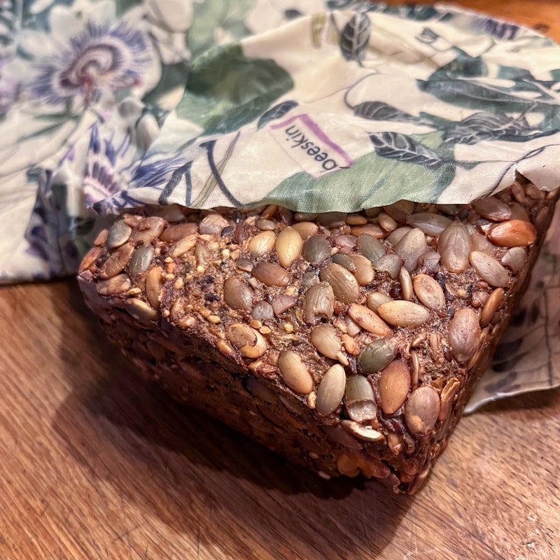 bread with grains on a wooden tablet wrapped in beeskin beeswax wrap passionflower