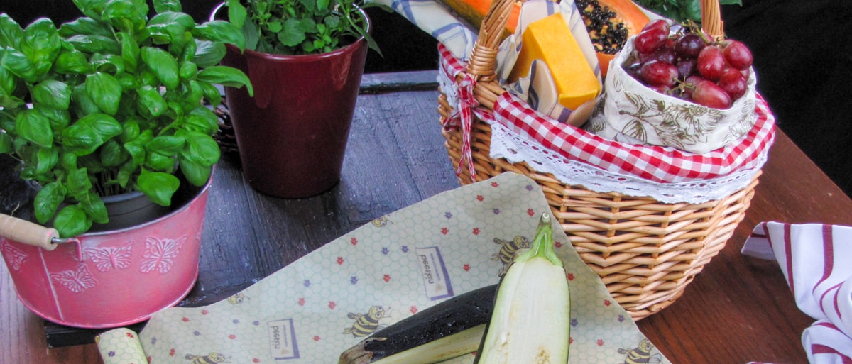 basket with different food wrapped in beeskin beeswax wraps for example cheese , grapes, papaya and cheese