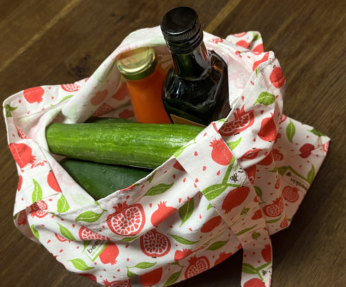 shopping bag pomegranate filled with cucumber and drinks