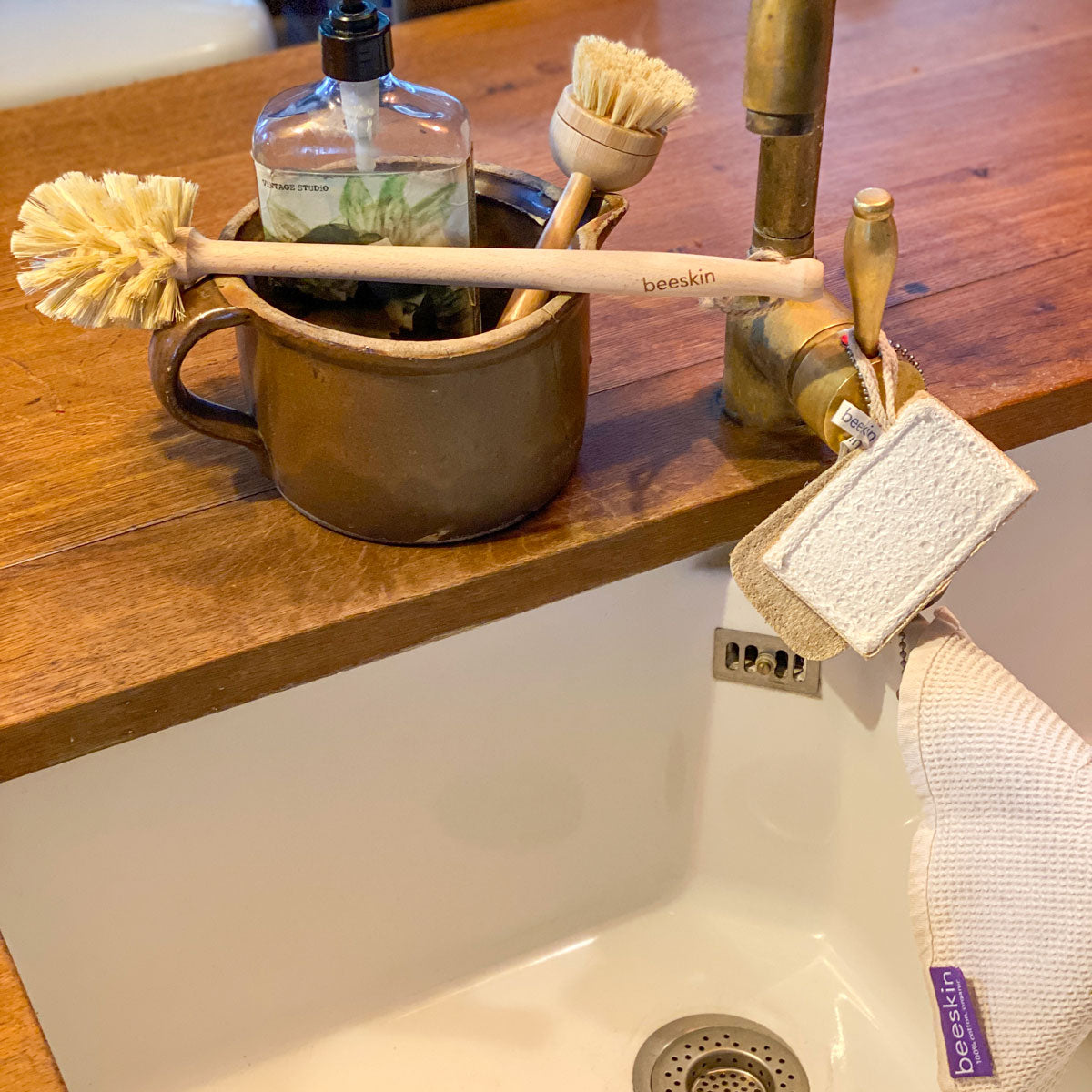 beeskin brushes and loofah placed near a white sink