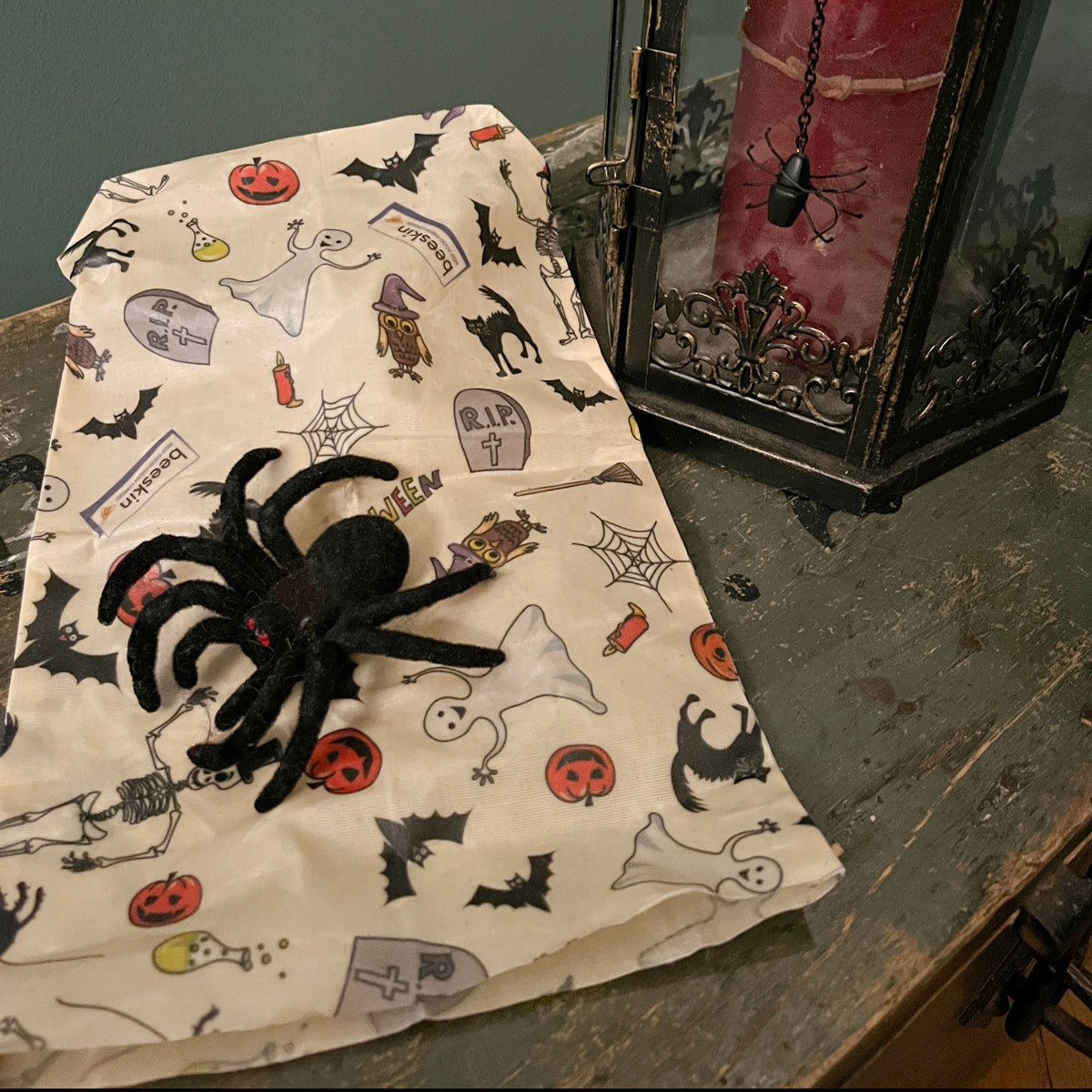 beeskin beeswax bag s with a black spider next to a red candle