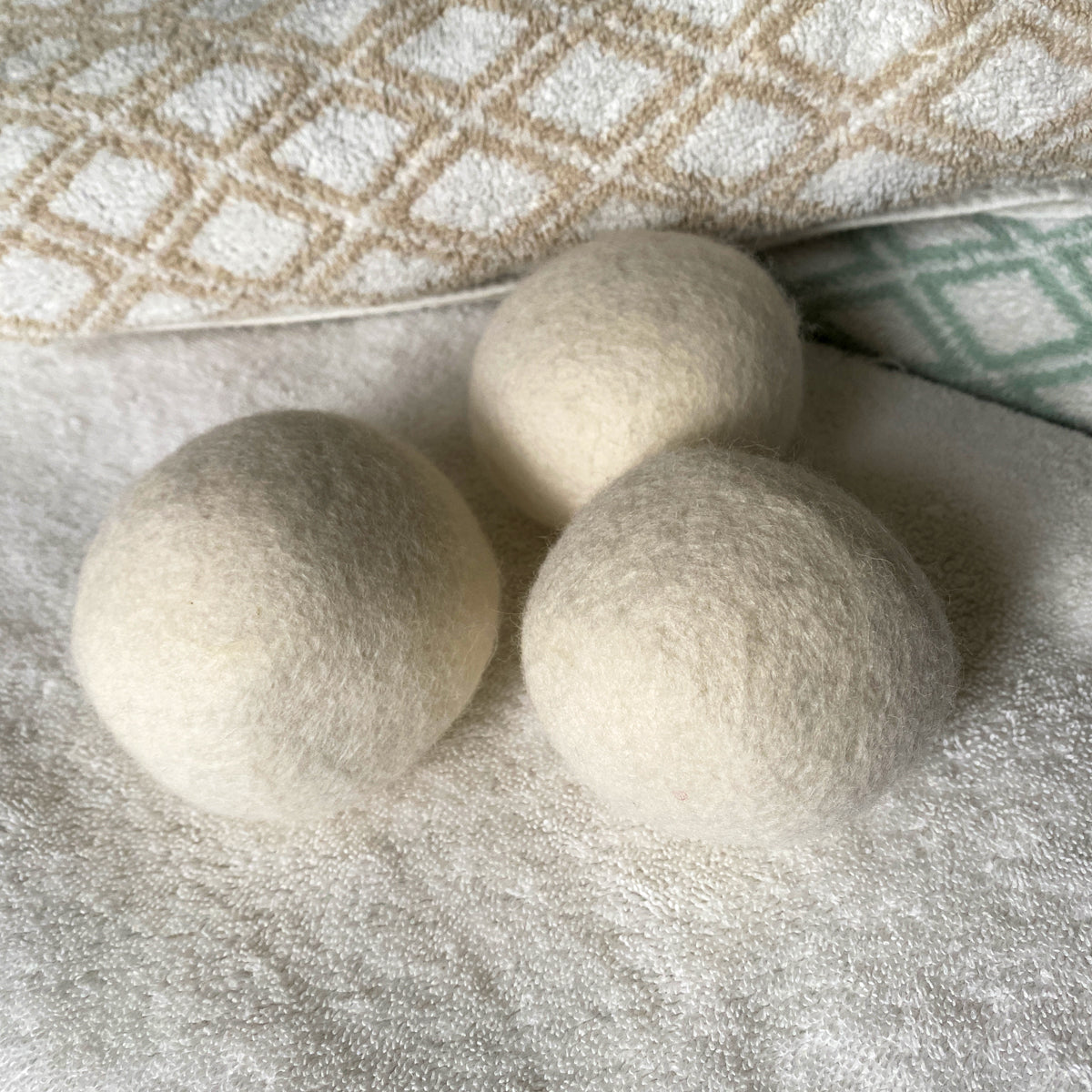 three wool dryer balls on towels