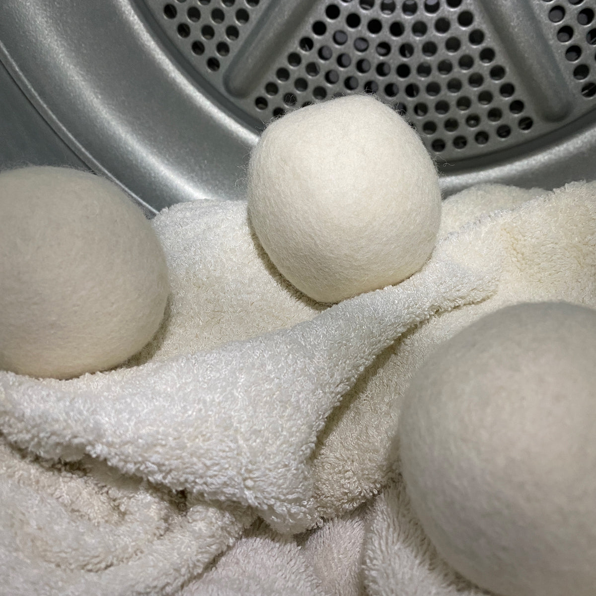 wool dryer balls and towels inside the dryer