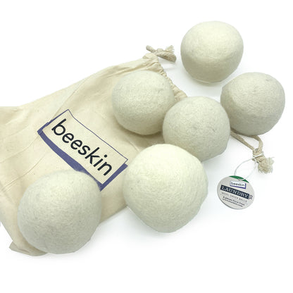 six wool dryer balls next to fabric packaging 