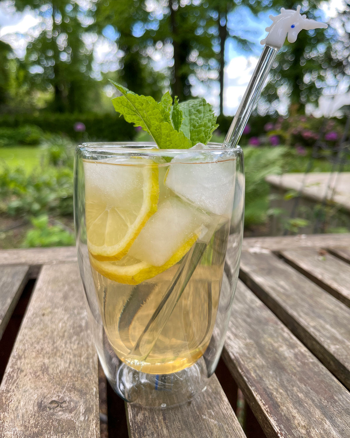beeskin double walled glass 450 ml filled with lemon ice tea on a garden table 