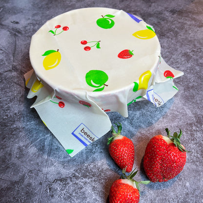 beeskin beeswax wrap fruit covering a bowl and strawberries on the table 