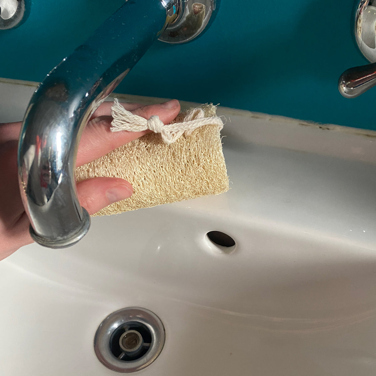 hand using beeskin loofah to clean the sink