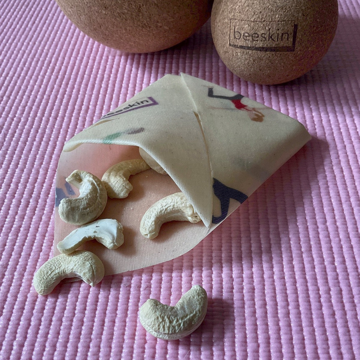 envelope folded out of beeswax wrap Yoga with nuts on a pink sports mat and cork fascia balls