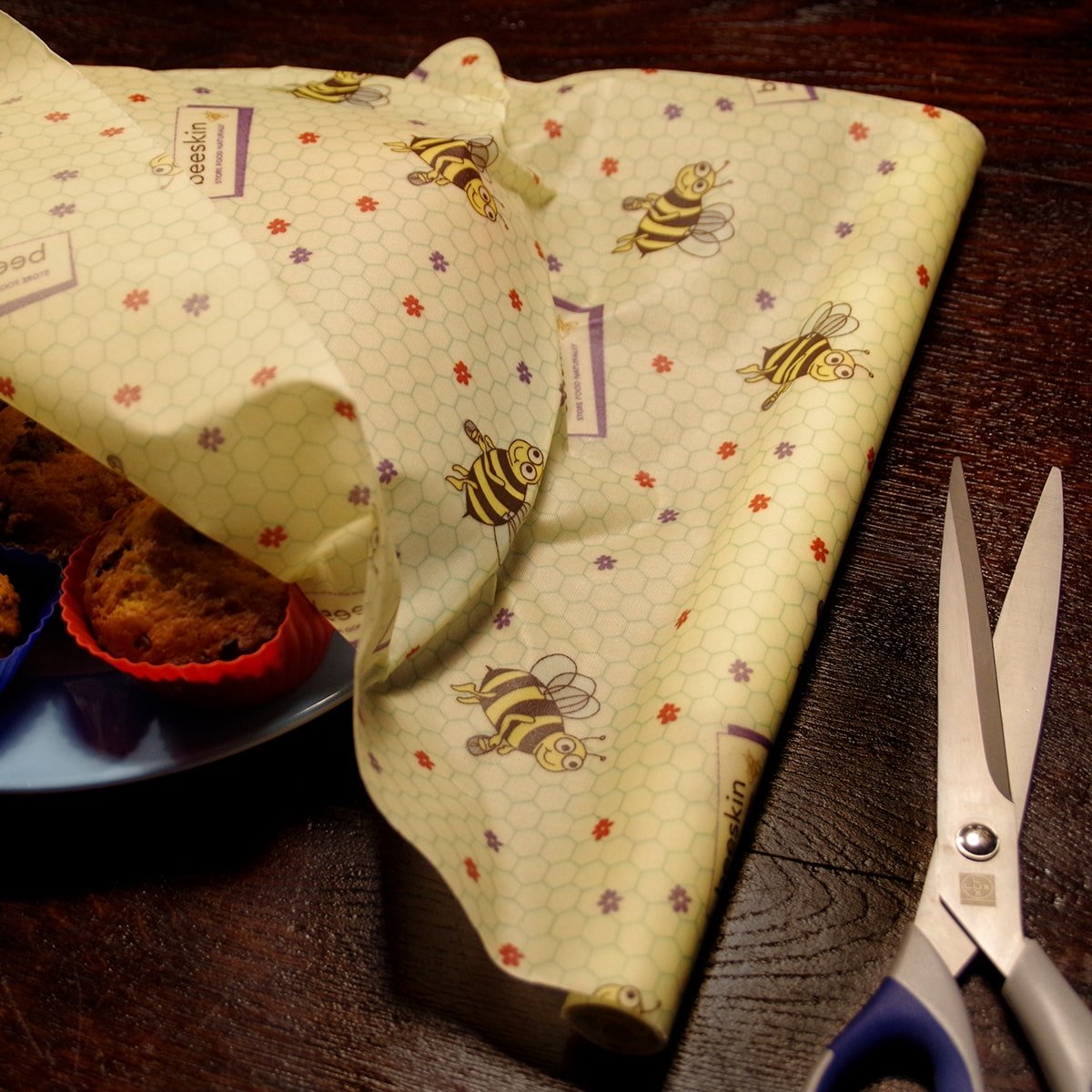 beeskin beeswax roll little bees covering a plate with muffins on it and scissors to cut the perfect size