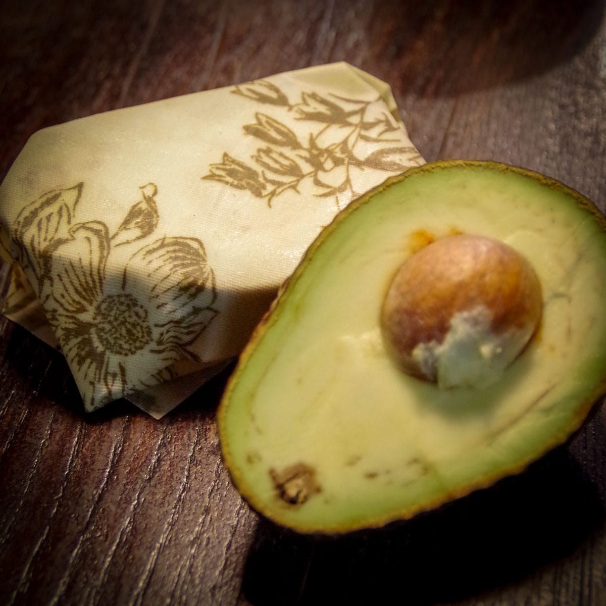 avocado cut in half and wrapped in beeswax wrap s flower