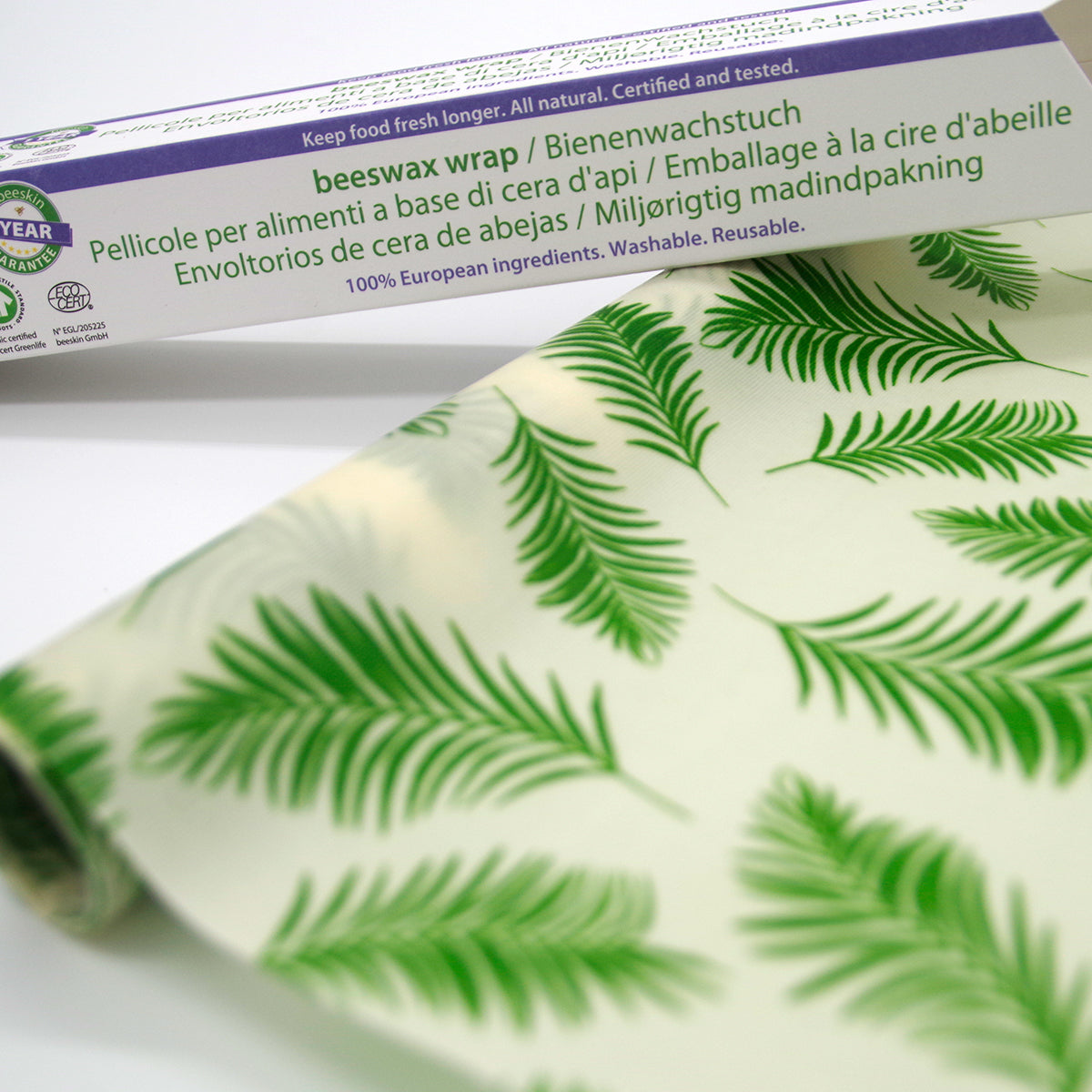 beeskin beeswax roll palm leaves next to packaging 